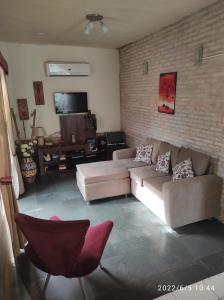 a living room with a couch and a brick wall at Casa de 4 habitaciones con piscina en barrio cerrado a 5 minutos del Aeropuerto Internacional in Luque