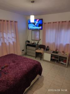 a bedroom with a bed and a flat screen tv at Casa de 4 habitaciones con piscina en barrio cerrado a 5 minutos del Aeropuerto Internacional in Luque