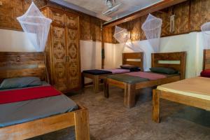 Soffta Surf Ranch في جنرال لونا: غرفة بها ثلاثة أسرة بطابقين وجدران خشبية