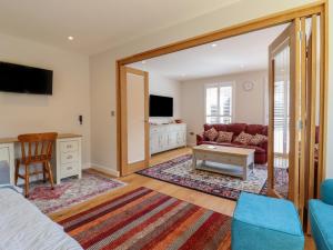 a living room with a couch and a tv at Wellington Cottage in Ely
