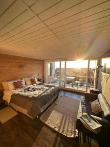 a bedroom with a large bed and a balcony at SaldeMar Playa Hermosa in Pichilemu