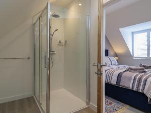 a glass shower in a bedroom with a bed at Wellington Cottage in Ely +24 photos