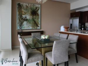 Un comedor con una mesa de cristal y sillas. en Icon Vallarta Beach front By Bamboo Skylife, en Puerto Vallarta