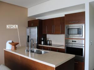 a kitchen with a sink and a microwave at Icon Vallarta Beach front By Bamboo Skylife in Puerto Vallarta