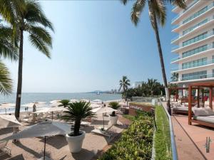 a view of a beach with palm trees and a building at Icon Vallarta Beach front By Bamboo Skylife in Puerto Vallarta