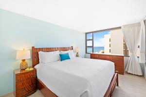 a bedroom with a large bed and a large window at Waikiki condo - ocean views, lanai & beach access in Honolulu