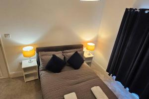 a bedroom with a bed with two lamps on two tables at Alfred House in Ripley