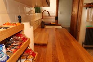 Cosy home in London في لندن: مطبخ مع أرضيات خشبية وكاونتر مع طعام