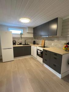 eine Küche mit grauen Schränken und einem weißen Kühlschrank in der Unterkunft Leilighet til leie på Klepp nært Borestranden in Klepp