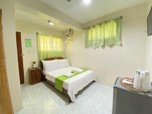ein kleines Schlafzimmer mit einem Bett und einem Tisch in der Unterkunft WHITEBEACH DE BORACAY STATION 1 (EXTENSION) in Boracay