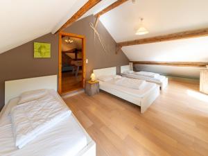 2 camas en un dormitorio ático con suelo de madera en Quaint Holiday Home near Forest in Lierneux en Lierneux