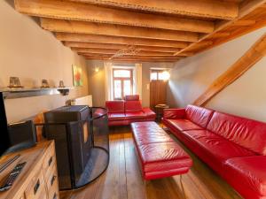 sala de estar con muebles de cuero rojo y TV de pantalla plana en Quaint Holiday Home near Forest in Lierneux en Lierneux