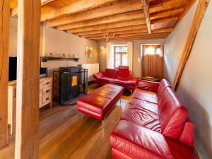 sala de estar con muebles de cuero rojo y chimenea en Quaint Holiday Home near Forest in Lierneux en Lierneux