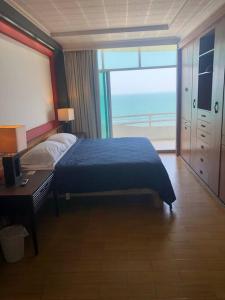 a bedroom with a blue bed and a large window at Sexto piso y vista al mar in Boca del Río +20 photos