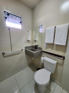 un baño con inodoro y lavabo en Vila Leal Hospedaria, en Penha