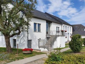 un edificio blanco con escaleras y un árbol en Luxury Family Holiday Home with Wellness en Binsfeld