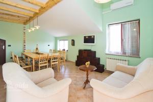 een woonkamer met 2 witte stoelen en een tafel bij Holiday Home lynn in Višnjan