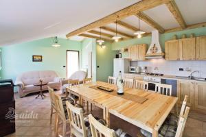 Holiday Home lynn في فيشنيان: مطبخ وغرفة معيشة مع طاولة وكراسي خشبية