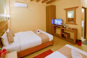una camera d'albergo con letto e TV di Paradise Boutique Hotel a Pokhara