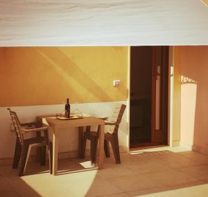 a table with two chairs and a bottle of wine at B&b La lumaca in Torchiarolo