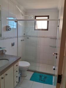La salle de bains est pourvue d'une douche, de toilettes et d'un lavabo. dans l'établissement Apartamento na Praia do Morro -160 metros da praia -Ar condicionado e internet -Perto de tudo, à Guarapari