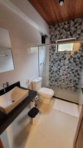 a bathroom with a white toilet and a sink at Alloggio Peterle in Domingos Martins