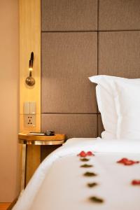 Estrella Boutique Hotel في دا نانغ: غرفة نوم بسرير ابيض وموقف ليلي