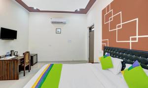 Habitación con cama, escritorio y TV. en Ranthambore Resort en Sawāi Mādhopur