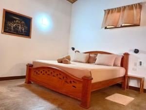 um quarto com uma cama de madeira num quarto em TamaHostel & Glamping em Tamarindo