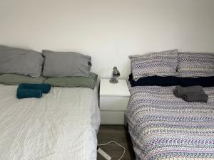 two beds sitting next to each other in a bedroom at Wembley Homes Serviced Apartment, 25mins to Central London in Wembley