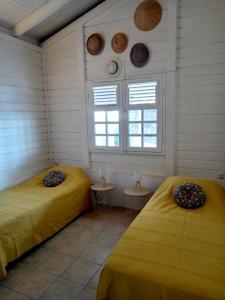 two beds in a room with two windows at VILLA KARAT in Le Diamant