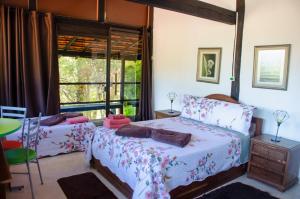 a bedroom with two beds and a window at Pousada Estância Vip in Cunha
