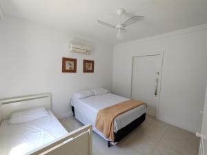 um quarto com 2 camas e uma ventoinha de tecto em Casa Sol Nascente em Cabo Frio