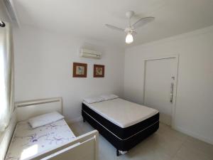 a bedroom with two beds and a ceiling fan at Casa Sol Nascente in Cabo Frio