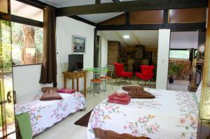 ein Zimmer mit zwei Betten und einem Tisch und Stühlen in der Unterkunft Pousada Estância Vip in Cunha