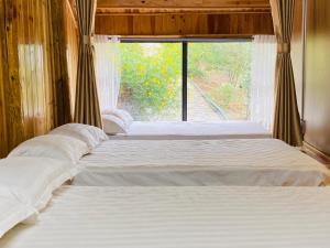 a couple of beds in a room with a window at Sapawine Homestay in Sapa