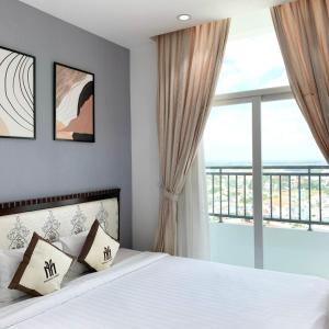 a bedroom with a bed and a large window at Căn hộ Khách sạn cao cấp Marina Plaza Long Xuyên in Ấp Ðông An (1)