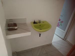 La salle de bains d'angle est pourvue d'un lavabo vert. dans l'établissement Renata Cottage, à Langgur