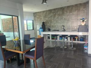 a kitchen with a counter and a table and chairs at Habitaciones Casa Blanca Oaxtepec Tlayacapan in Oaxtepec