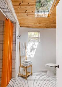 a bathroom with a toilet and a wooden ceiling at Walk to coffee, bars, eats — The Cozy Bungalow in Austin