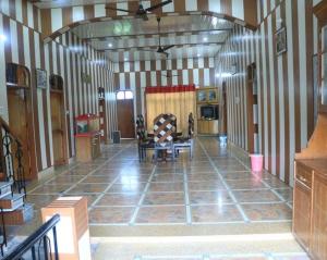 a large hallway with a room with striped walls at Flagship Corbett Farm Homestay in Rāmnagar