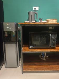 eine Mikrowelle auf einem Regal neben einem Kühlschrank in der Unterkunft Pai Apart #1 in Pai