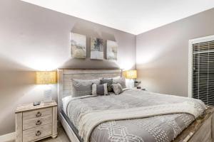 a bedroom with a large bed with a wooden headboard at Sand & Sea by DC in Seaside