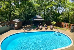 a swimming pool in a yard with a gazebo at Wolfs Den at Tradewinds - Pool in Eureka Springs