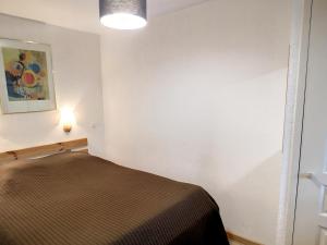 Zimmer mit einem Bett und einer Lampe an der Wand in der Unterkunft Appartement Les Menuires, 3 pièces, 5 personnes - FR-1-178-379 in Les Bruyères