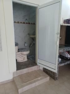 a bathroom with a toilet and a door open at Casa Amelia in San Blas
