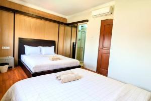 twee bedden in een hotelkamer met twee bedden bij Cottonwood Japandi Apartment at Majesty 1222 in Bandung