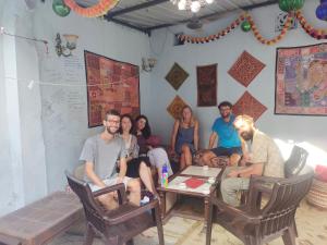 um grupo de pessoas sentadas à volta de uma mesa numa sala em Little prince guest house & homestay em Bikaner