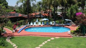 a swimming pool with a slide in a yard at Posada Los Alcatraces in Atlixco