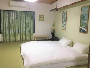 um quarto com uma cama branca e uma janela em Fortune House*JR 鶴橋なんばまで5分*観光便利*一軒家 最大6人 em Osaka